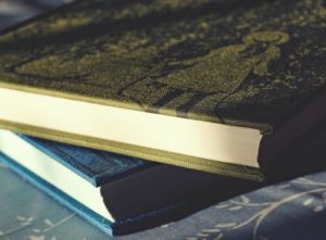 Stack of books, blue and green covers on a table